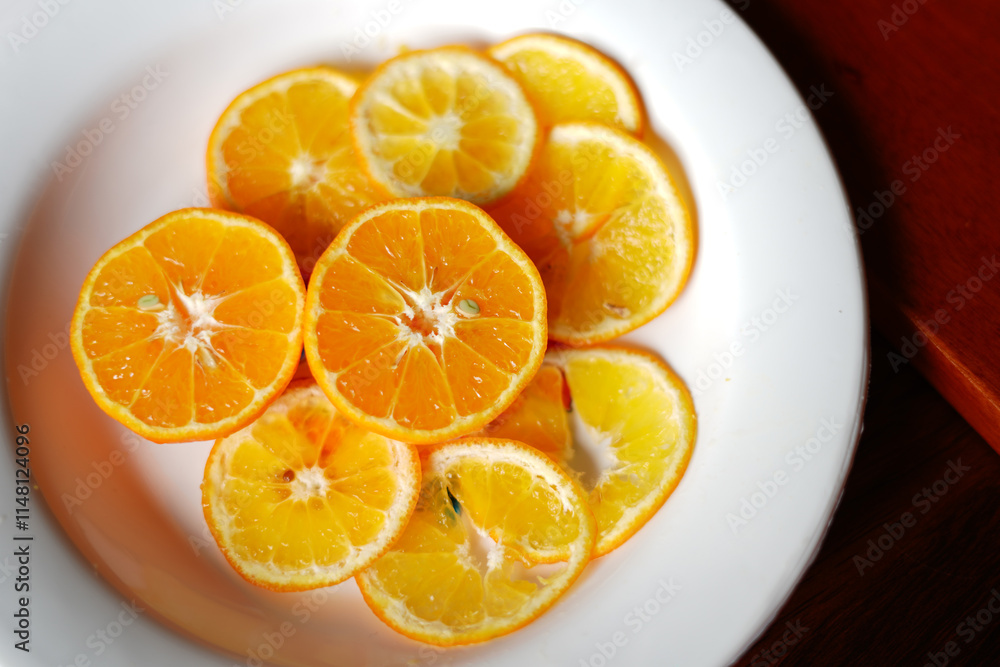Perfectly Sliced Orange with white dish on table. Stock Photo Perfectly Sliced Orange with white dish on table. Stock Photo