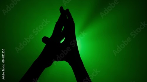 Wallpaper Mural Hand silhouette showing gesture crossing fingers holding palms together against bright green colored spotlight, isolated on studio background close up shot. Torontodigital.ca