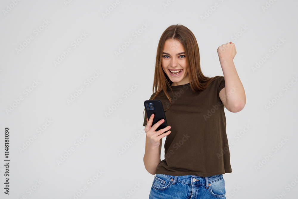 Portrait of a happy joyful woman holding mobile phone and celebrating a win isolated over white background Portrait of a happy joyful woman holding mobile phone and celebrating a win isolated over white background