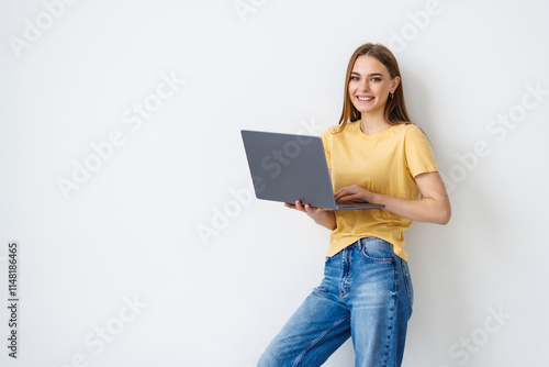 Portrait of a happy woman holding laptop computer iand looking away isolated over white background photo