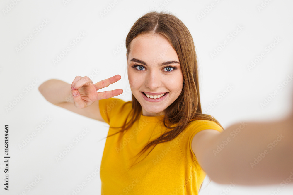 Young woman winking while taking selfie photo isolated over white background Young woman winking while taking selfie photo isolated over white background