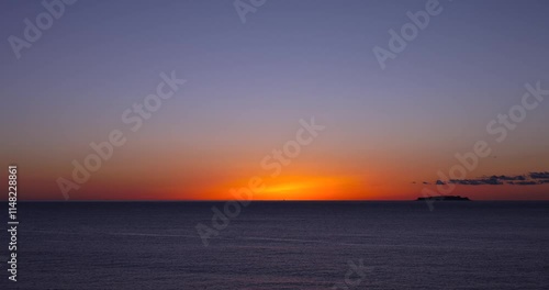 朝焼けに染まる夜明け前の海の風景。