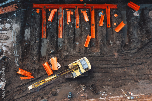 Aerial view from drone at Construction site with heavy machinery and orange equipment in use during daylight hours photo