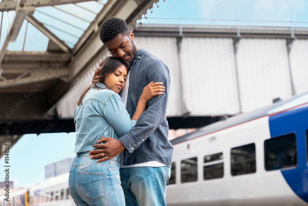 Couple shares a tender moment at the train station as they embrace before departure Couple shares a tender moment at the train station as they embrace before departure