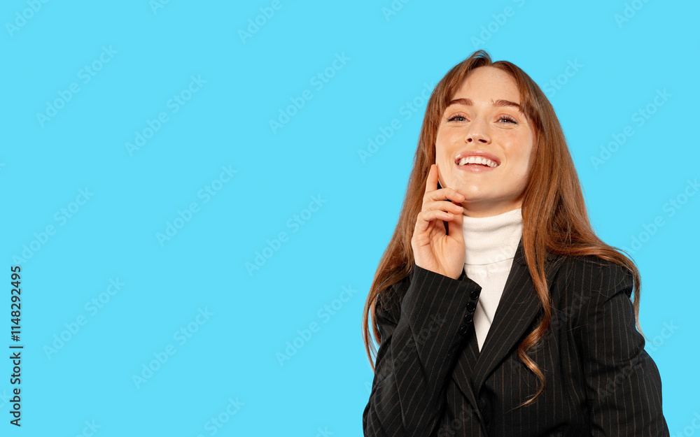 Young woman in business attire smiling with a blue background while posing thoughtfully in a professional setting Young woman in business attire smiling with a blue background while posing thoughtfully in a professional setting
