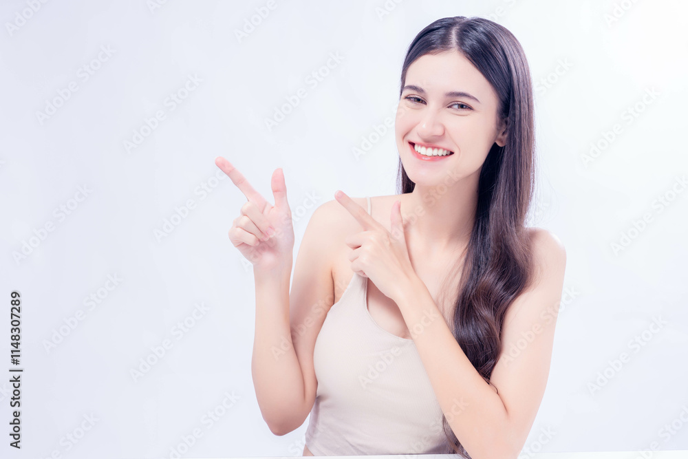 Smiling Young beautiful woman pointing to empty copy space isolated on white background Smiling Young beautiful woman pointing to empty copy space isolated on white background