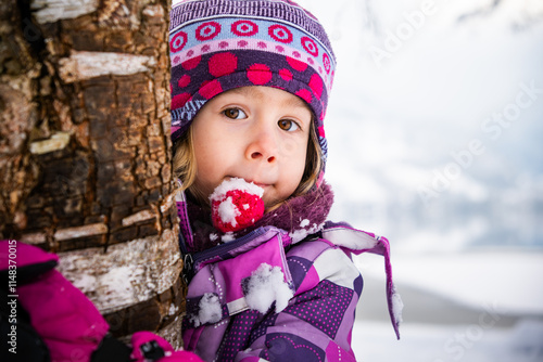 Portrait of preschool girl hugging a tree during Winter in Austria photo