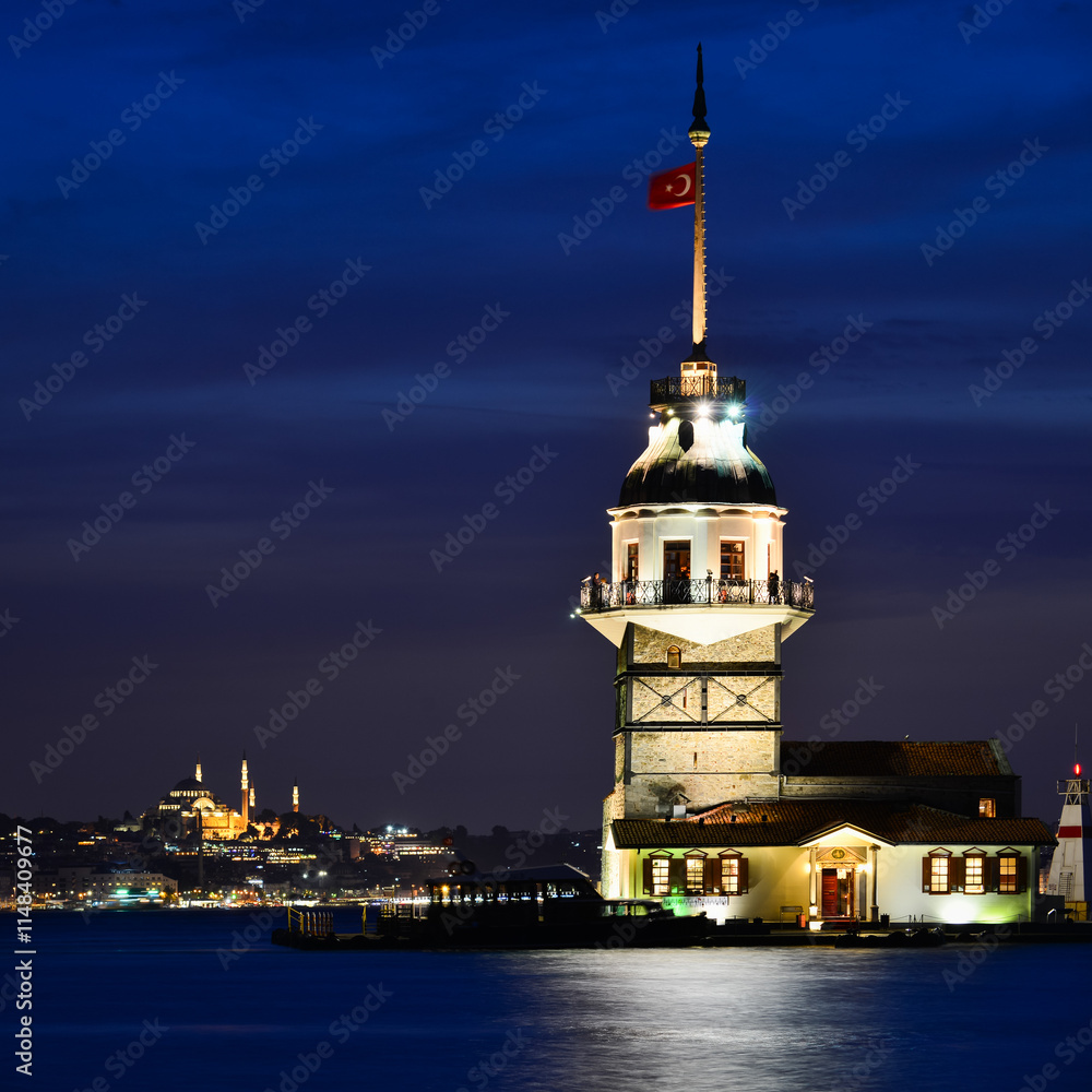 Fototapeta premium Maiden's Tower or Kiz Kulesi at night with motion blur boats - Istanbul, Turkey.