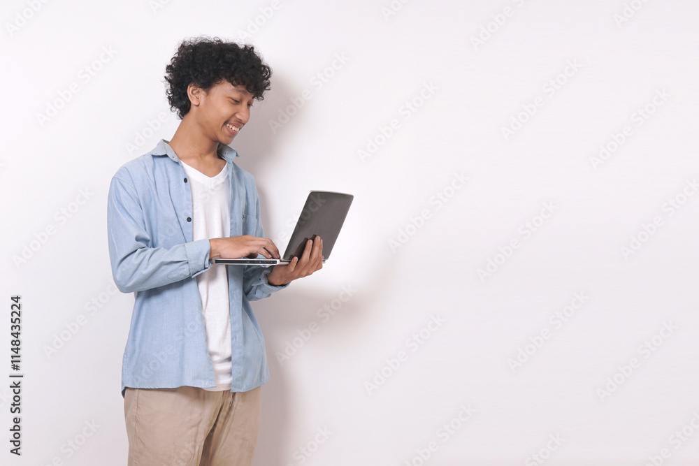 young man standing and holding laptop with smile isolated on white background. young man standing and holding laptop with smile isolated on white background.