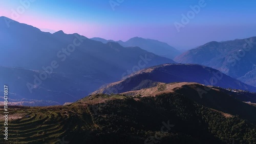 view of rugged hills at golden hour, where the sunlight casts glowing hues on the slopes and valley