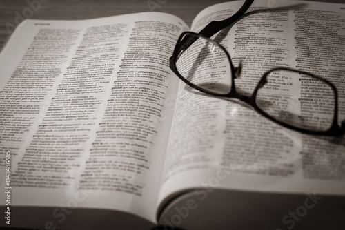 A pair of glasses lies on an open Swedish dictionary