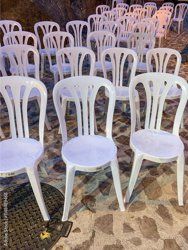 Rows of plastic chairs set up for an outdoor concert
