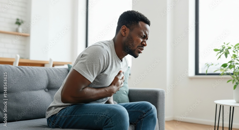 African male adult experiencing chest pain at home, health and well-being concept