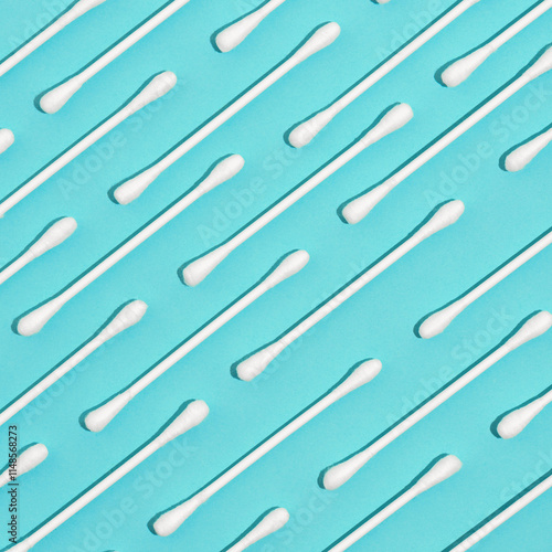 Pattern of white cotton swabs for personal hygiene on blue background. Concept of hygiene, medicine, health care and beauty photo