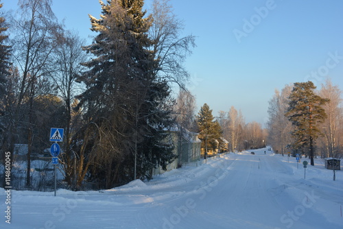 Real estate, houses, buildings, structures, infrastructure, Varkaus, Finland. Beautiful winter streets, alleys with roads, cars, cyclists, sidewalks, green fir trees, birches, trees, covered snow. photo