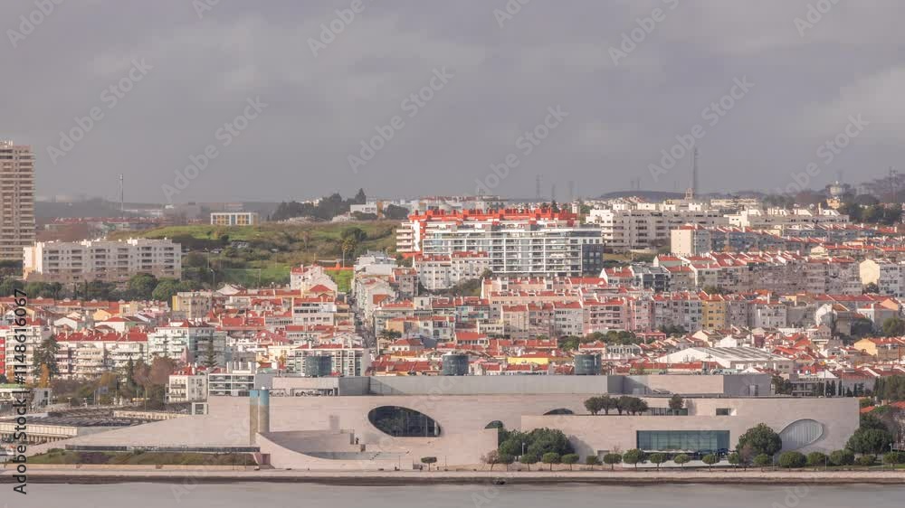 Aerial timelapse of waterfront and the Champalimaud Foundation's Amphitheatre overlooking the Tagus River in Lisbon, Portugal. A modern biomedical research center surrounded by houses with red roofs. Aerial timelapse of waterfront and the Champalimaud Foundation's Amphitheatre overlooking the Tagus River in Lisbon, Portugal. A modern biomedical research center surrounded by houses with red roofs.