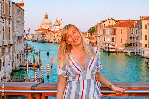 Obraz na płótnie A Beautiful Tourist woman Standing on a Scenic Bridge in Venice During a Stunning Sunset View of Venices Grand Canal w salonie