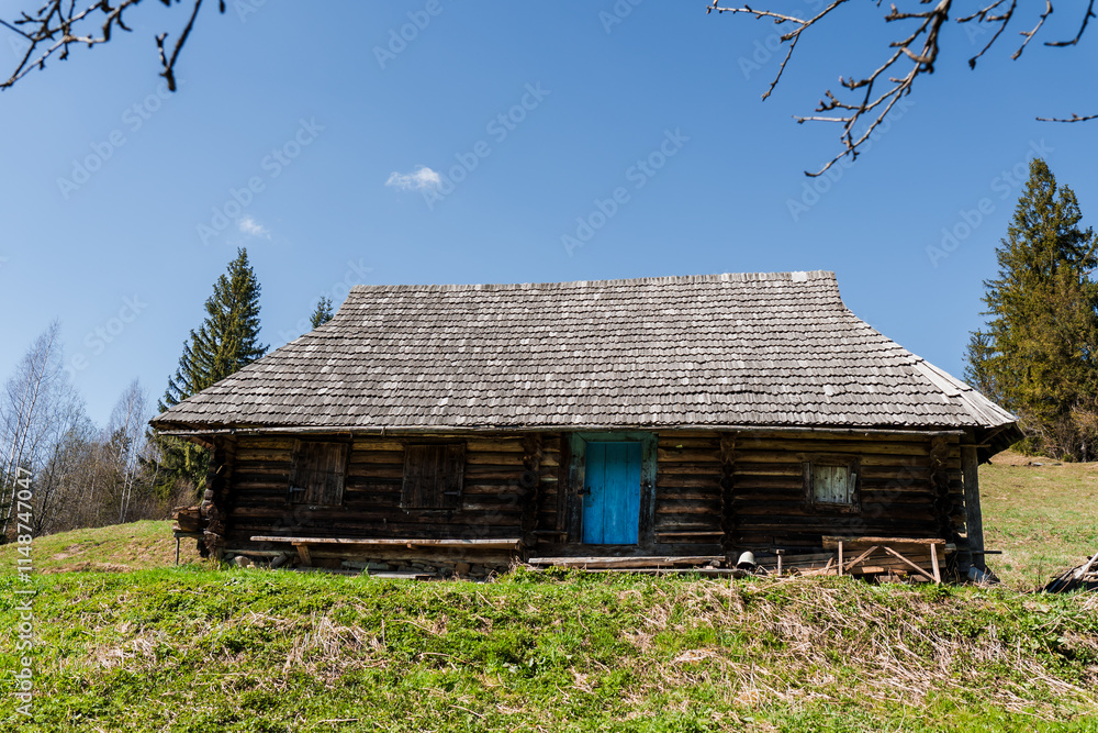 Rustic log cabin under a clear blue sky surrounded by greenery and trees Rustic log cabin under a clear blue sky surrounded by greenery and trees