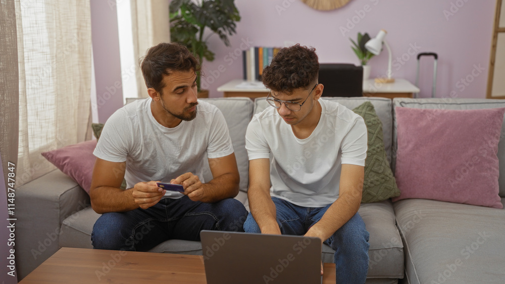 Father and son sitting in a cozy living room using a laptop, showcasing family love and connection in an indoor home setting with modern decor and casual attire Father and son sitting in a cozy living room using a laptop, showcasing family love and connection in an indoor home setting with modern decor and casual attire