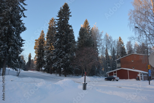 Beautiful winter streets, alleys with roads, cars, cyclists, sidewalks, green fir trees, birches, trees, covered with white, fluffy snow. Infrastructure, Varkaus, Finland.  photo