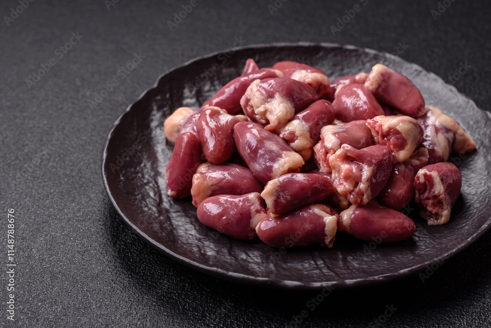 Raw chicken hearts with salt, spices and herbs Raw chicken hearts with salt, spices and herbs