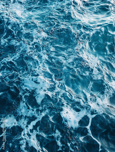 Calm blue ocean waves create beautiful patterns of foam