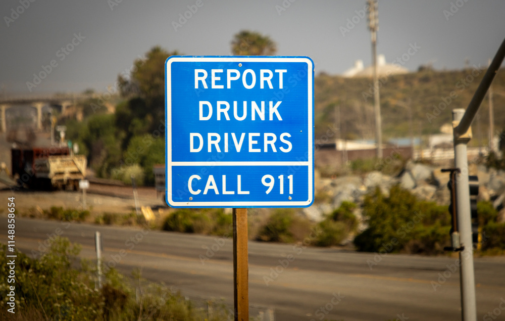 A blue traffic sign stating Report Drunk Drivers call 911 A blue traffic sign stating Report Drunk Drivers call 911