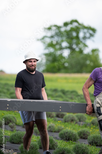 A man helps carry the already assembled floor for the gazebo. photo