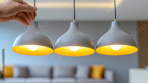 Aperson installing decorative pendant lights in a contemporary living room photo