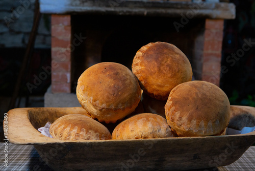 round and crispy artisanal bread freshly taken out of the wood-fired oven. traditional bakery in Romania photo