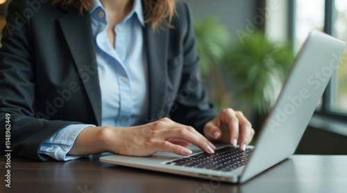 Close-up of a girl at a laptop in an office doing work.