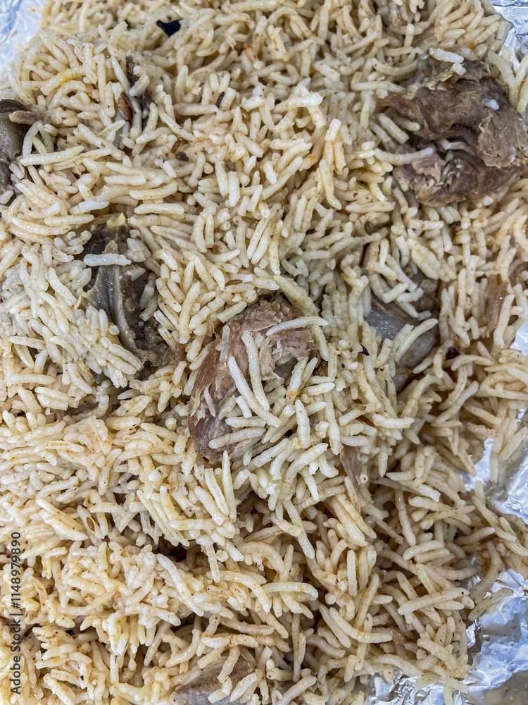Festive pilaf Kacchi Mutton Biryani with nuts, raisins, fried onion closeup on the plate