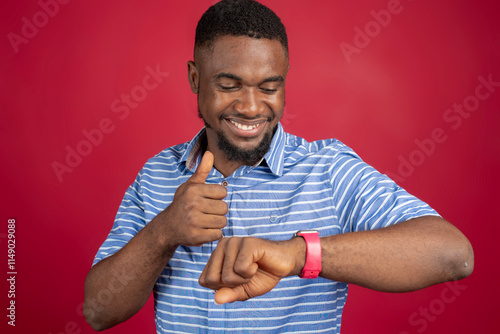 Young African American pointing his finger at his wrist watch