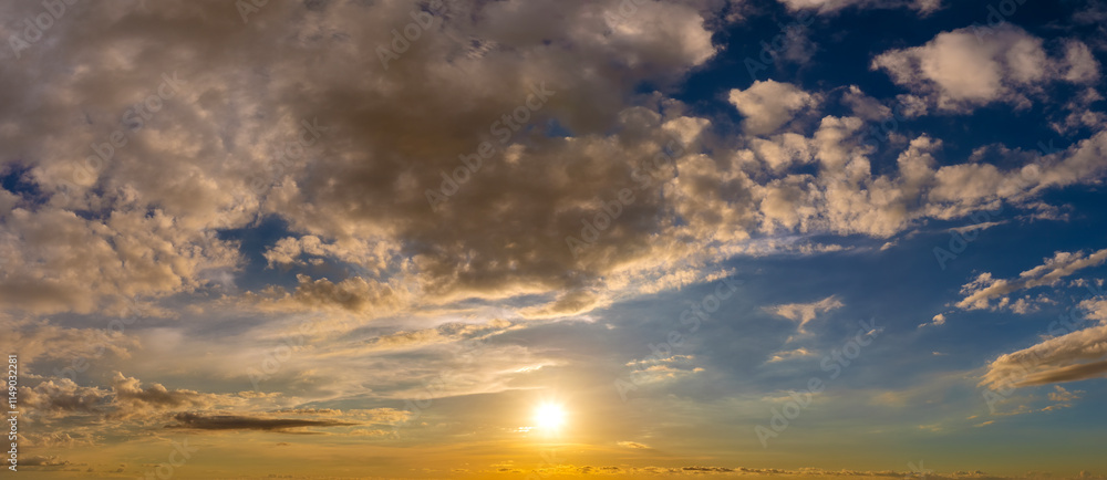 Colorful sunset sky with setting sun behind vivid orange and yellow clouds Colorful sunset sky with setting sun behind vivid orange and yellow clouds
