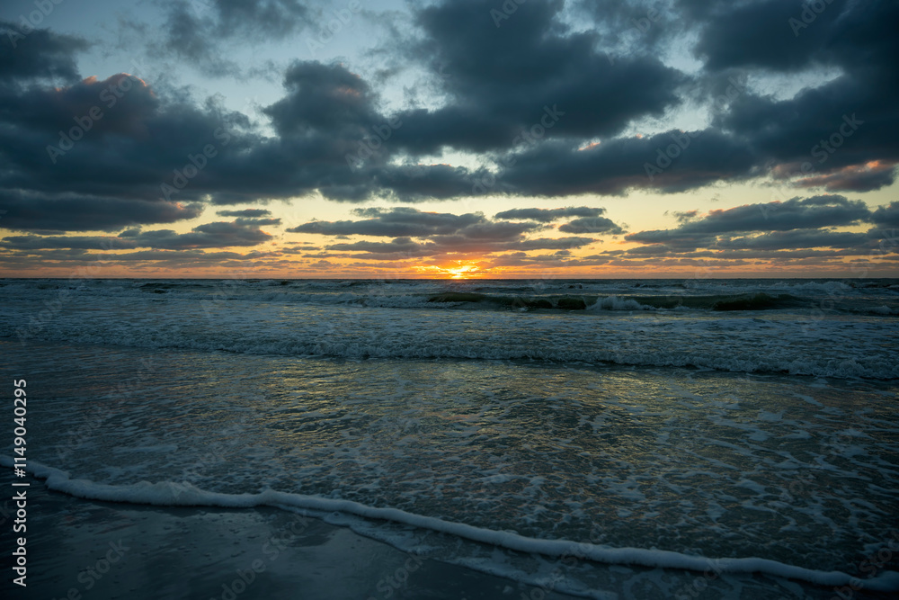 Obraz premium Ocean sunset landscape with soft evening sea water waves crushing on sandy beach