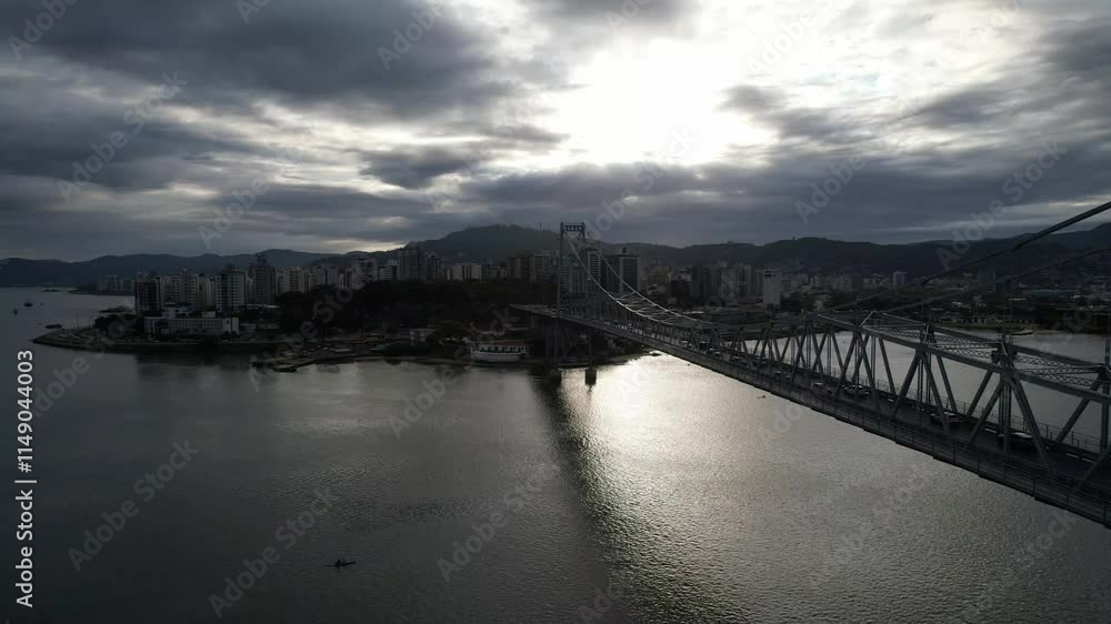 Drone view of Florianópolis' central region at sunset, showcasing urban landscapes, historic architecture, and the surrounding bay with its shimmering waters under the evening light. Drone view of Florianópolis' central region at sunset, showcasing urban landscapes, historic architecture, and the surrounding bay with its shimmering waters under the evening light.
