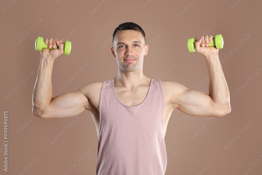 Man exercising with dumbbells on light brown background Man exercising with dumbbells on light brown background