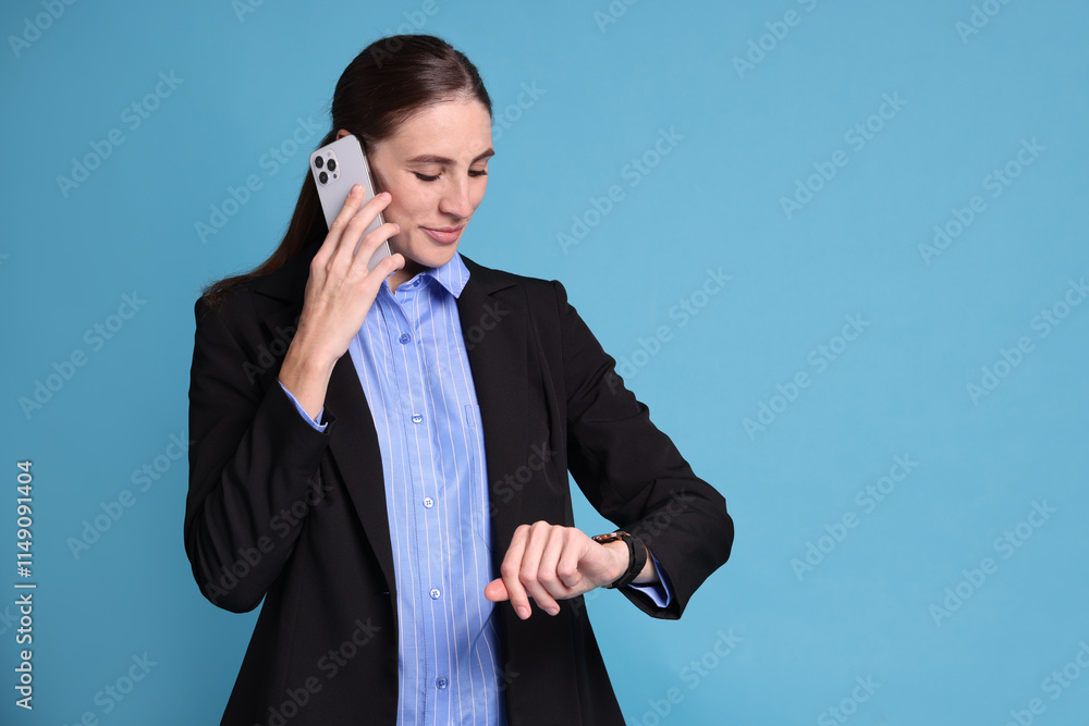 Banker checking time while talking on smartphone against light blue background, space for text Banker checking time while talking on smartphone against light blue background, space for text