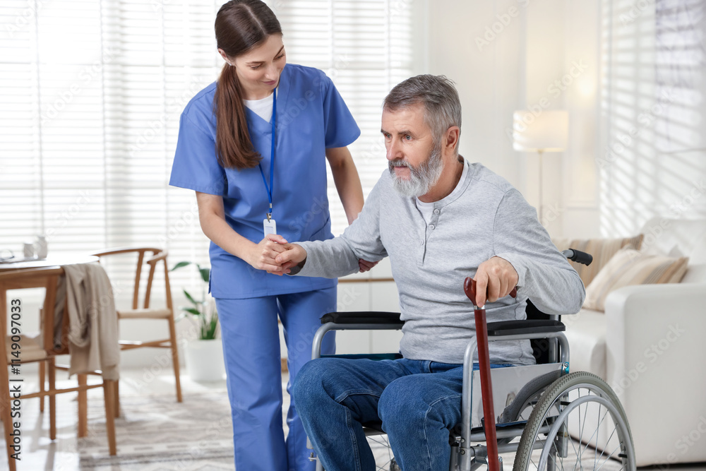 Caregiver assisting senior man in wheelchair indoors. Home health care service Caregiver assisting senior man in wheelchair indoors. Home health care service