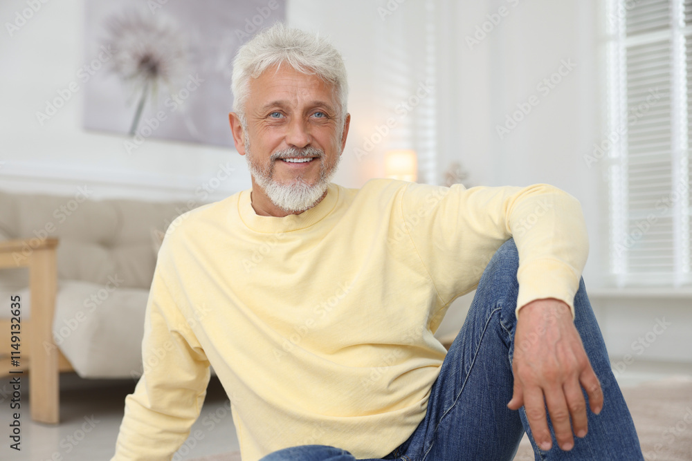 Smiling senior man sitting on floor at home Smiling senior man sitting on floor at home
