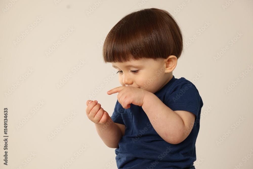 Portrait of cute little boy on light grey background. Space for text Portrait of cute little boy on light grey background. Space for text