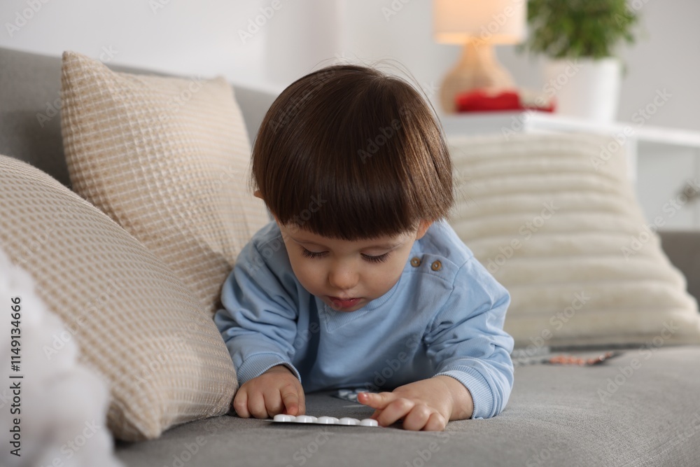 Little boy playing with pills on sofa at home. Child in danger Little boy playing with pills on sofa at home. Child in danger