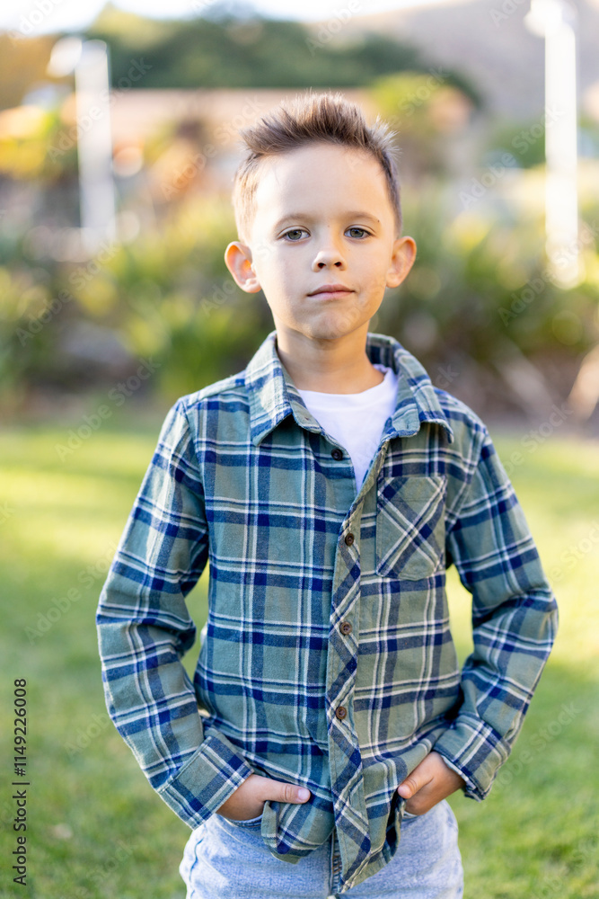 A young boy, exuding confidence and charm, stands proudly in a grassy area, dressed in a stylish plaid shirt layered over a simple white tee, embodying the essence of childhood joy and playfulness A young boy, exuding confidence and charm, stands proudly in a grassy area, dressed in a stylish plaid shirt layered over a simple white tee, embodying the essence of childhood joy and playfulness