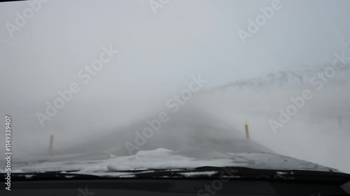 Inside car view of driving during extreme weather during winter snowing in Iceland