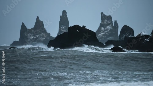 Panoramic view of basalt sea stacks Reynisdrangar from black sand beach Reynisfjara, Iceland