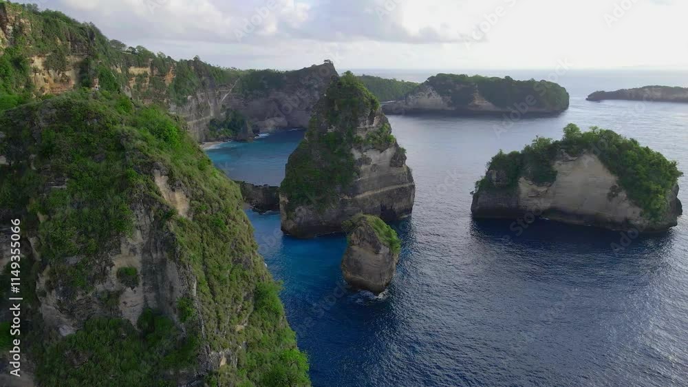 Aerial view of a lush green tropical island with rocky coastline and clear azure waters Aerial view of a lush green tropical island with rocky coastline and clear azure waters