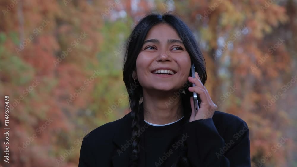 Confident woman connects with friends via a smartphone, her fashion-forward look matching the elegance of the park. Confident woman connects with friends via a smartphone, her fashion-forward look matching the elegance of the park.