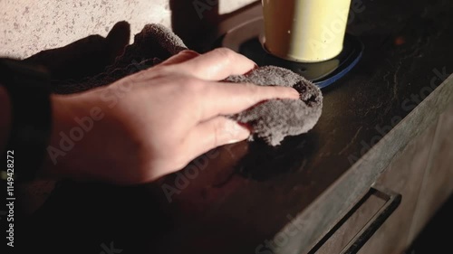 a hand cleaning spilled water after watering potted plant