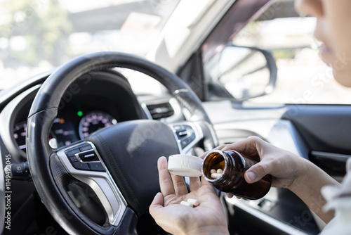 Woman pouring medicine capsule into her palm of hand,taking medication while driving a car,dangers of consuming certain drugs that can cause drowsiness or impair focus,risk of accidents,safety on road