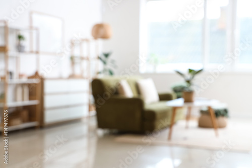 Blurred view of living room with green sofa  coffee table and plants